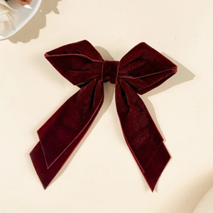 Macro detail of the wine red velvet bow hair clip with vintage texture and elegant design