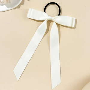 Elegant white satin ribbon bow hair tie with long streamers on beige background
