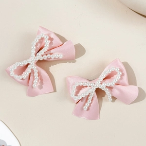 Set de barrettes à cheveux en satin rose avec perles sur fond minimaliste