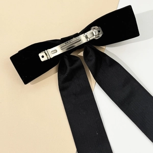 Detail of velvet bow hair clip showing secure metal spring clip with Paris engraving
