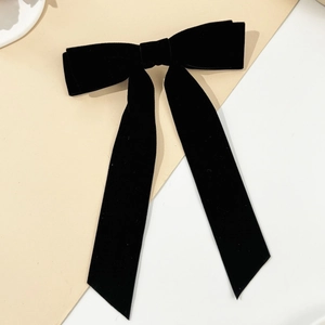 Elegant black velvet bow hair clip with long streamers in a vintage minimalist design