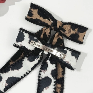 Detail view of the silver metal clip back with Paris engraving on leopard bow hair clip