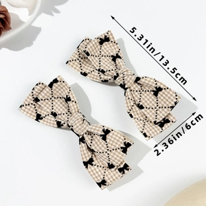 Détail de deux barrettes à carreaux marron montrant les dimensions de 13,5 cm et le tissu