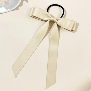 Detail of champagne gold satin ribbon bow hair tie with long flowing streamers