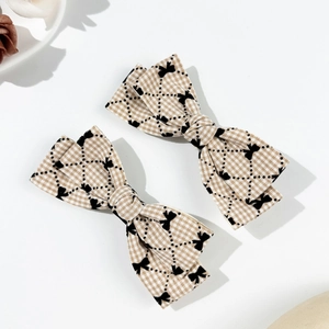 Détail de deux barrettes à carreaux avec motifs nœuds et texture de tissu raffinée