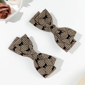 Détail de barrettes à nœud écossais style Maillard avec motif élégant en tissu à carreaux