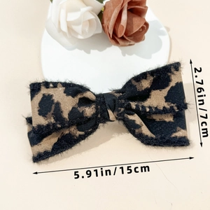 Leopard print bow hair clip with textured fabric showing 15cm length and 7cm width dimensions