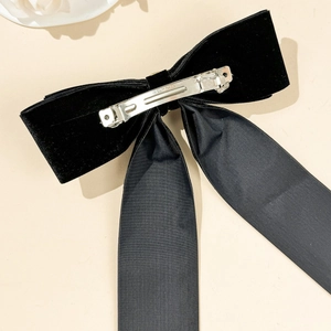 Detail of the back metal spring clip on a vintage black velvet bow hair accessory