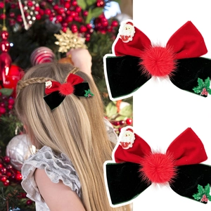 Detail of red velvet bow hair clip with Santa Claus figurine and festive holly berry decor