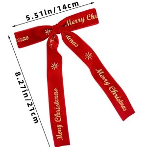 Détail d'un nœud de Noël en velours rouge avec lettrage doré Merry Christmas