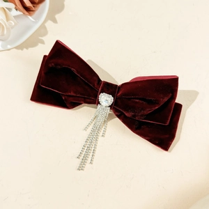 Detail of dark red velvet bow hair clip with sparkling heart rhinestone and fringe
