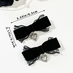 Détail de barrettes à nœud en velours noir gothique avec pendentifs cœur et croix