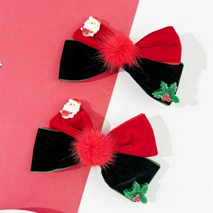 Detail of red and green velvet Christmas bow clips with mini Santa and pompom accents