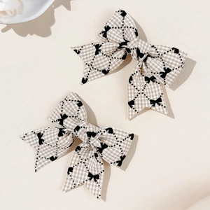 Détail de barrettes à cheveux à carreaux avec motifs noirs et texture de tissu élégante
