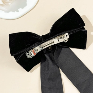 Detailed back view of velvet bow hair clip with silver metal spring fastener