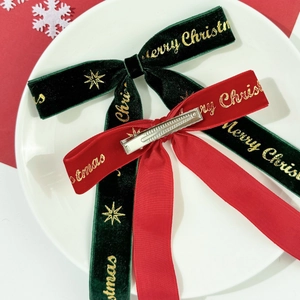 Détail de nœuds de Noël en velours avec texte doré et barrettes métalliques