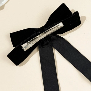 Detail view of the silver metal duckbill clip on the back of the black velvet bow hairclip
