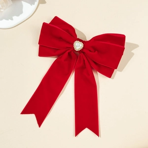 Detailed macro view of red velvet bow hairpin with a pearl heart and sparkling rhinestones