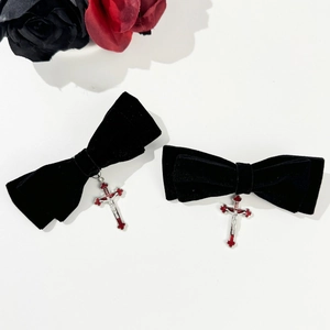 Detail view of gothic black velvet bow hair clips with silver and red cross pendants