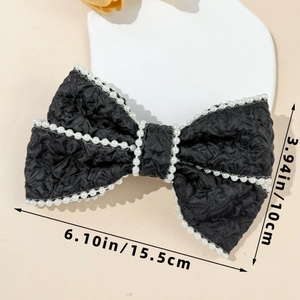 Detailed view of large black bow hair clip with pearl trim and dimensions 15.5cm x 10cm