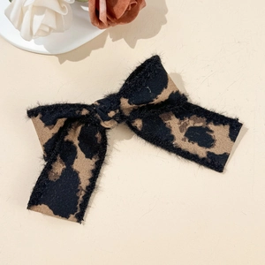 Close-up of leopard print bow hair clip with textured faux fur fabric and rich detail