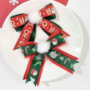 Détail de barrettes de Noël à nœuds avec motifs festifs et pompons en peluche doux