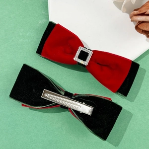 Detail of red and green velvet bow hair clips with crystal buckle and metal alligator clip