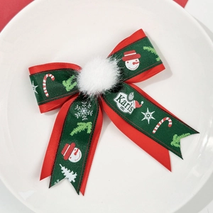 Détail de la pince à cheveux de Noël avec rubans rouge-vert, motifs bonhomme de neige et pompon