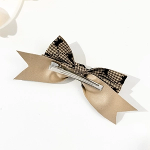Détail de la pince à cheveux double nœud à carreaux avec satin champagne et clip métallique