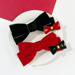 Barrettes à cheveux de Noël en velours rouge et vert sur un plateau en céramique blanche