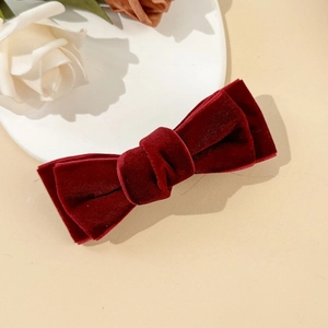 Detail van de gelaagde bordeauxrode fluwelen strik haarclip met een elegante textuur