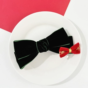 Détail de pinces à cheveux de Noël en velours vert foncé avec broderie dorée élégante