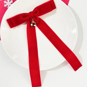 Barrette à cheveux avec nœud en velours rouge et pendentif couronne de Noël sur plat