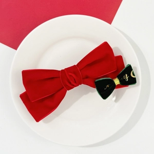 Détail des nœuds à cheveux en velours rouge et vert avec broderie dorée festive