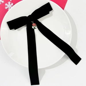 Barrette nœud en velours avec pendentif couronne de Noël sur assiette blanche élégante