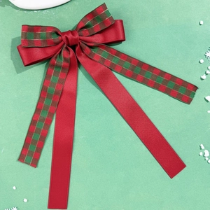 Détail du nœud de Noël en satin rouge et ruban à carreaux avec flocons de neige