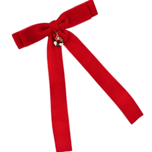 Barrette nœud de Noël en velours rouge avec pendentif couronne festive sur fond blanc