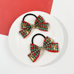 Détail de deux nœuds de cheveux de Noël à carreaux rouge et vert avec gaufrage de renne doré