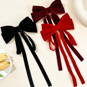 Three velvet bow hair clips with long ribbons in black, wine red, and bright red colors