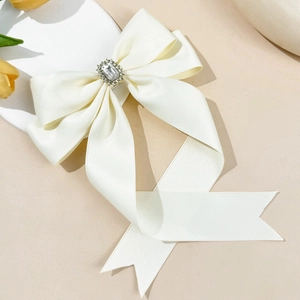 Elegant cream satin bow hair clip with crystal embellishment and long flowing ribbons