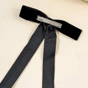 Detail view of the silver metal spring clip on the back of the black velvet bow hair clip