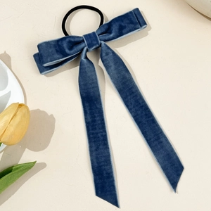 Detailaufnahme eines dunkelblauen Samt-Haargummis mit langen, eleganten Bändern