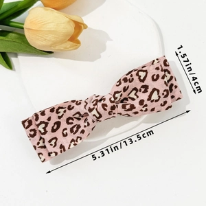 Detail view showing dimensions of pink leopard print bow hair clip with fabric texture