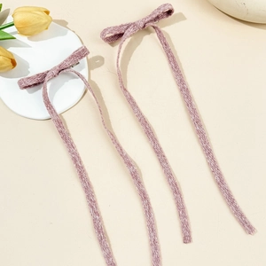Dettaglio di due fermagli per capelli a fiocco stile balletto lavanda con nastri lunghi