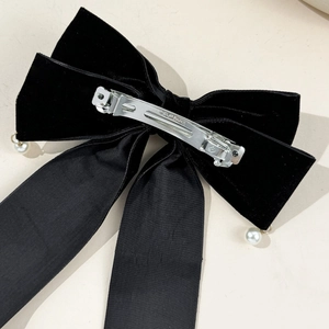 Close-up of the silver spring clip mechanism with Clip Paris engraving on velvet bow