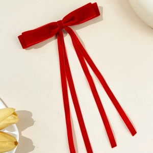 Detail view of red velvet double layer bow hairpin with long flowing ribbons