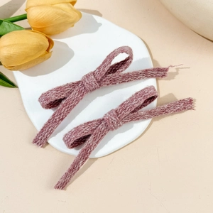 Detailed macro view of two pink knitted bow hair clips with soft textured fabric