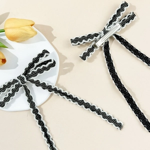 Paire de barrettes à nœud papillon noir et blanc à bords ondulés avec pinces à bec de canard
