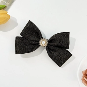 Detail of French style black bow hair clip with pearl and rhinestone centerpiece