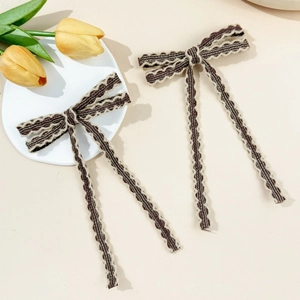Détail d'une pince à cheveux en tricot avec soie dorée lurex et bord festonné